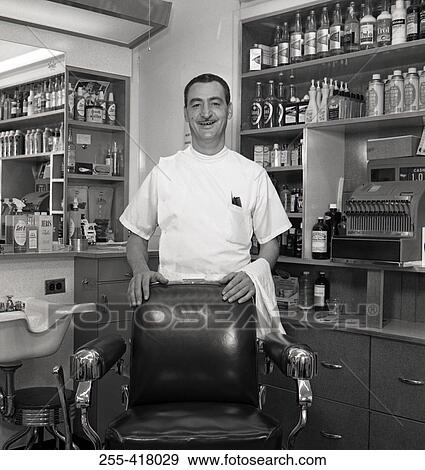 Stock Photo - Barber standing behind chair in barber shop. Fotosearch