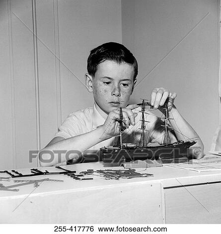 Boy building ship model View Large Photo Image Stock Photograph - Boy building ship model. Fotosearch