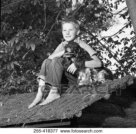Boy embracing dog on shed roof View Large Photo Image Stock Photo - Boy embracing dog on shed roof. Fotosearch