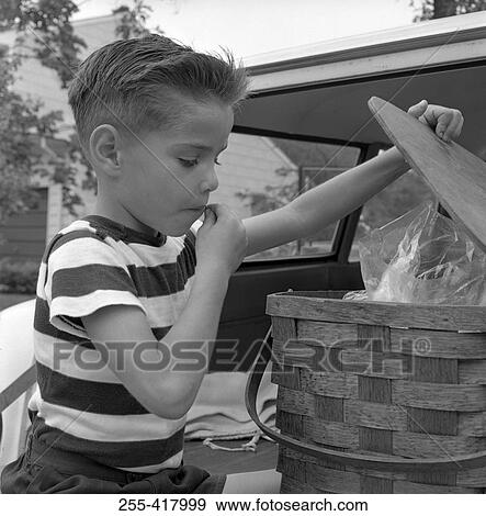 Stock Photo - Boy opening picnic basket. Fotosearch