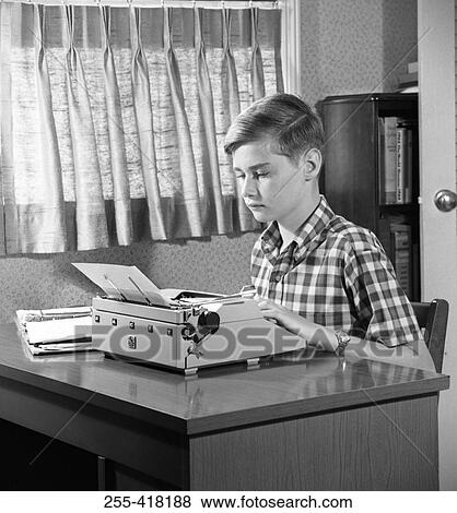 Stock Photo - Boy typing on typewriter. Fotosearch