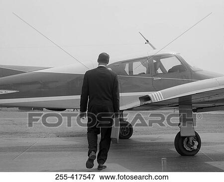 Businessman approaching private plane View Large Photo Image Stock Photo - Businessman approaching private plane. Fotosearch