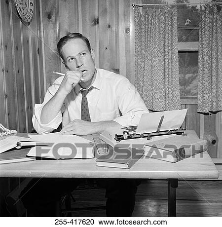 Businessman working at desk in home office View Large Photo Image Stock Image - Businessman working at desk in home office. Fotosearch