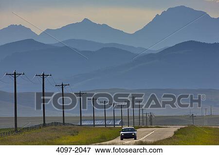 Car on road with mountains in the background, Rocky Mountains, Alberta, Canada View Large Photo Image Stock Photo - Car on road with mountains in the background, Rocky Mountains, Alberta, Canada. Fotosearch