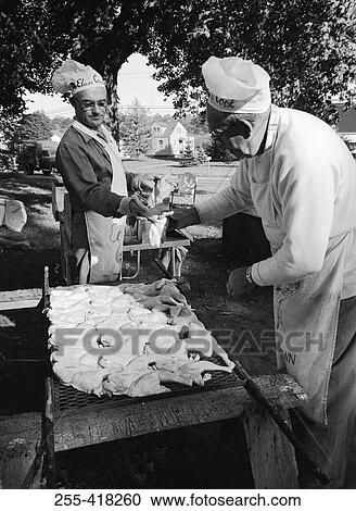 Stock Image - Chef preparing meat in garden. Fotosearch