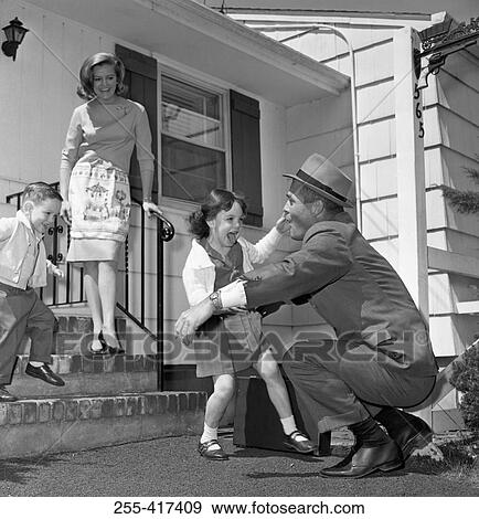 Stock Photo - Children running to say hallo to father, mother standing on steps. Fotosearch