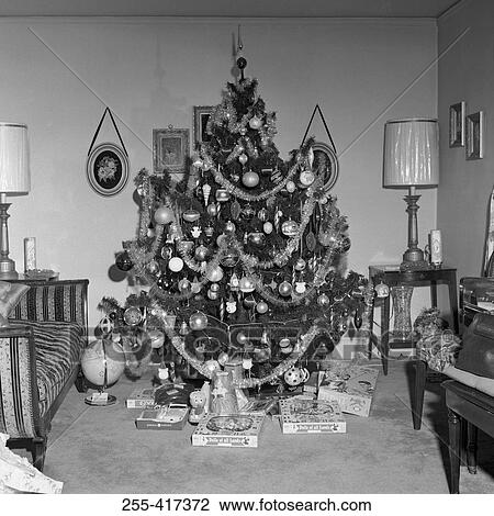 Stock Image - Christmas tree with Christmas gifts in living room. Fotosearch