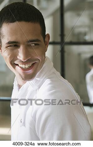 Stock Image - Close-up of a man smiling, Manhattan, New York City, New York State, USA. Fotosearch