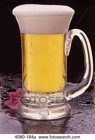 Stock Image - Close-up of a mug of beer with sports tickets. Fotosearch