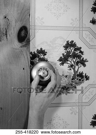 Stock Image - Close up of hand on knob. Fotosearch
