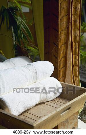 Stock Photo - Close-up of rolled up white towels on a tray at a spa. Fotosearch