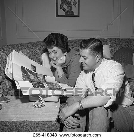Couple reading adverts in newspaper View Large Photo Image Stock Photo - Couple reading adverts in newspaper. Fotosearch