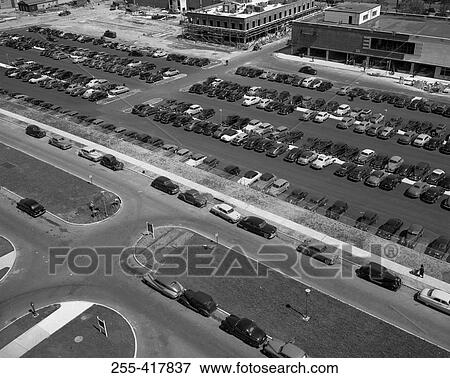 Stock Photo - Elevated view of cars on street and parking lot by supermarket. Fotosearch