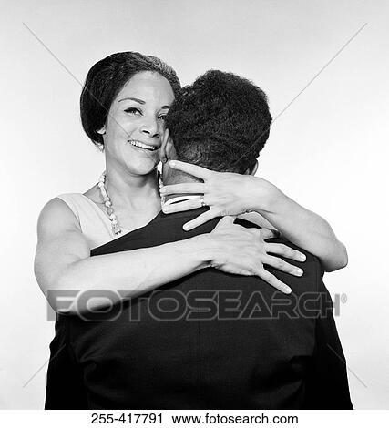 Stock Image - Embracing African-american married couple, studio shot. Fotosearch
