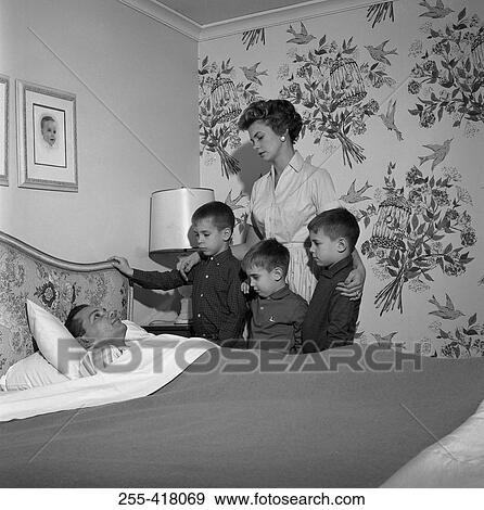 Family around ill father's bed View Large Photo Image Stock Photo - Family around ill father's bed. Fotosearch
