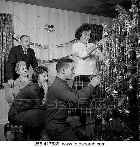 Stock Photo - Family preparing Christmas tree in living room. Fotosearch