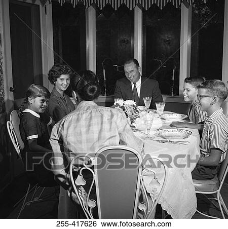 Stock Photograph - Family with children at dining room table. Fotosearch
