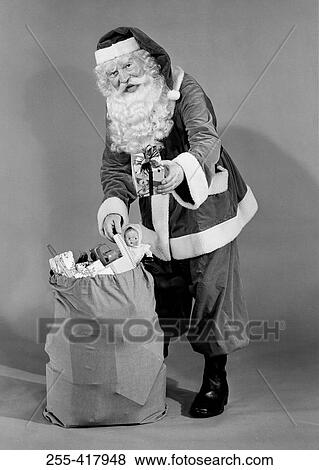 Father christmas pulling present from sack View Large Photo Image Stock Photo - Father christmas pulling present from sack. Fotosearch