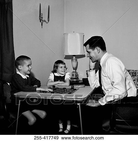 Stock Photo - Father playing draughts with son and daughter. Fotosearch