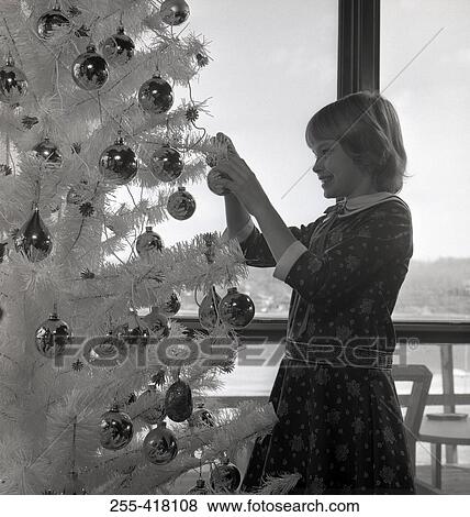 Girl decorating Christmas tree View Large Photo Image Stock Photo - Girl decorating Christmas tree. Fotosearch