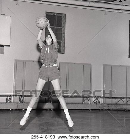 Stock Image - Girl jumping with basketball ball. Fotosearch
