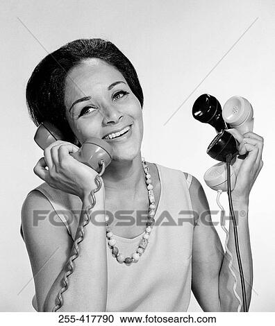 Stock Image - Happy African-American woman holding receivers. Fotosearch