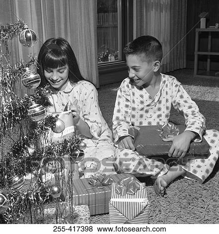 Happy children with Christmas gifts near Christmas tree View Large Photo Image Stock Photo - Happy children with Christmas gifts near Christmas tree. Fotosearch