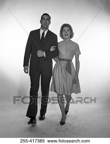 Stock Photography - Happy mid adult couple walking, studio shot. Fotosearch