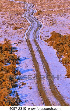 Stock Image - High angle view of tire tracks on a snow covered road, Thompson-Okanagan, British Columbia, Canada. Fotosearch