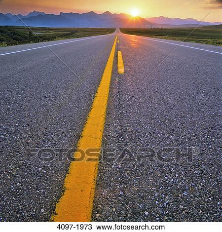 Stock Image - Highway passing through a landscape with mountains in the background, Canadian Rockies, Waterton Lakes National Park, Alberta, Canada. Fotosearch