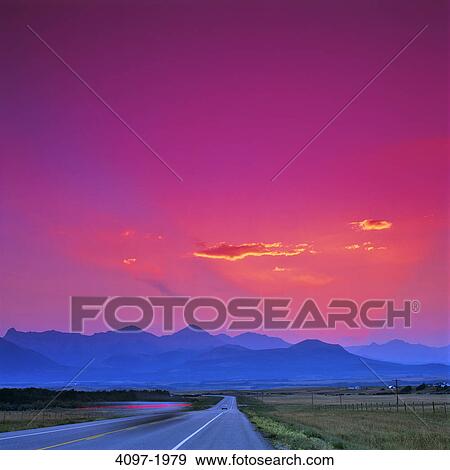 Stock Photo - Highway passing through a landscape with mountains in the background, Canadian Rockies, Waterton Lakes National Park, Alberta, Canada. Fotosearch
