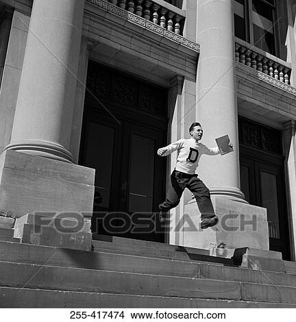 Picture - Low angle view of man rushing out building. Fotosearch