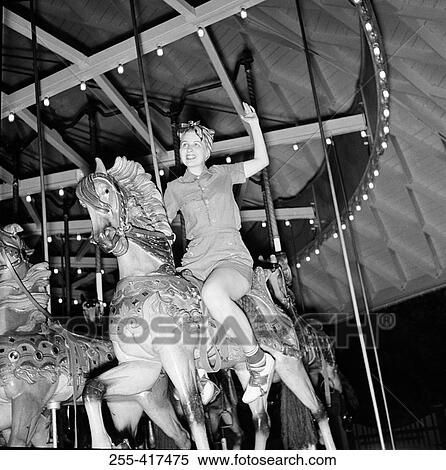 Low angle view of woman riding carousel View Large Photo Image Stock Photography - Low angle view of woman riding carousel. Fotosearch