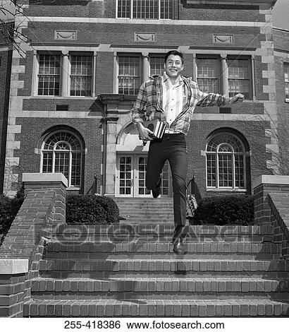Male student jumping down steps outside university View Large Photo Image Stock Photograph - Male student jumping down steps outside university. Fotosearch