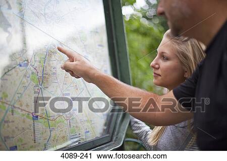 Stock Image - Man and his daughter looking at Paris metro map, Paris, Ile-De-France, France. Fotosearch