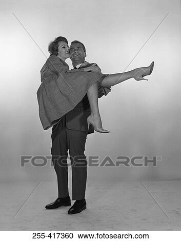 Man laughing and carrying woman, studio shot View Large Photo Image Stock Image - Man laughing and carrying woman, studio shot. Fotosearch