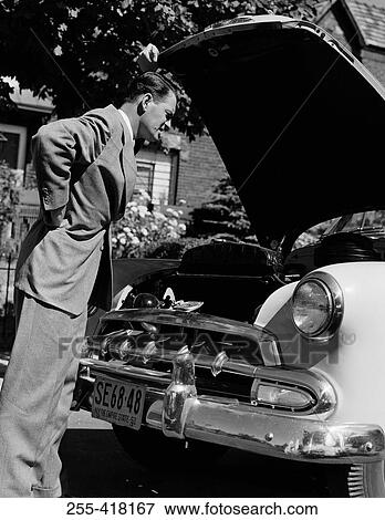 Stock Photo - Man looking into car hood. Fotosearch