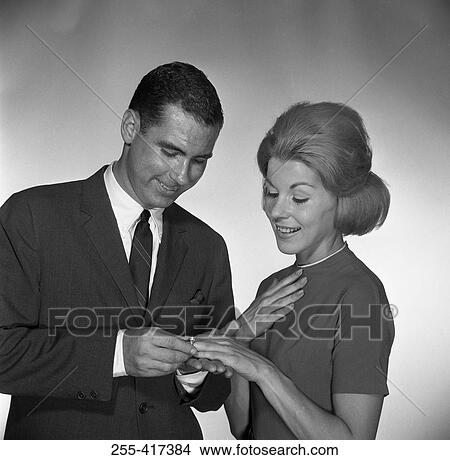 Man putting ring on woman's palm, studio shot View Large Photo Image Picture - Man putting ring on woman's palm, studio shot. Fotosearch