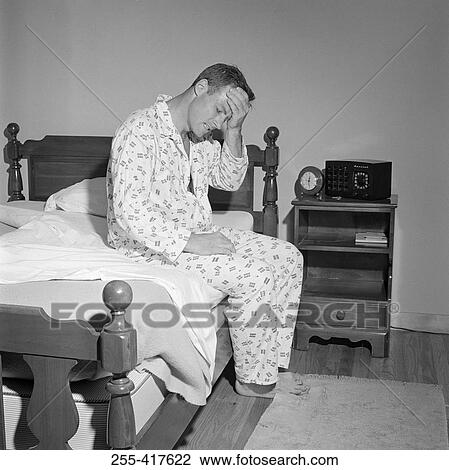 Man with headache, sitting on bed View Large Photo Image Stock Image - Man with headache, sitting on bed. Fotosearch