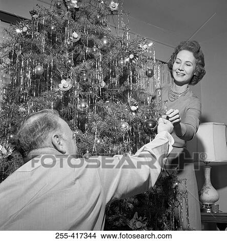 Picture - Mature couple decorating Christmas tree. Fotosearch