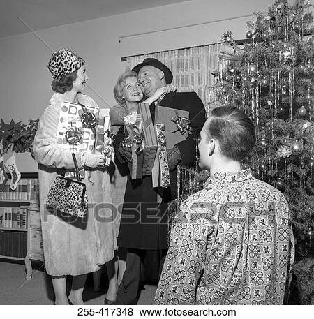 Stock Photo - Mature couple with Christmas gifts greetings married children. Fotosearch