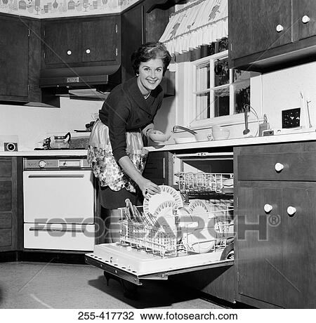 Mature housewife washing dishes in dishwasher View Large Photo Image Stock Image - Mature housewife washing dishes in dishwasher. Fotosearch