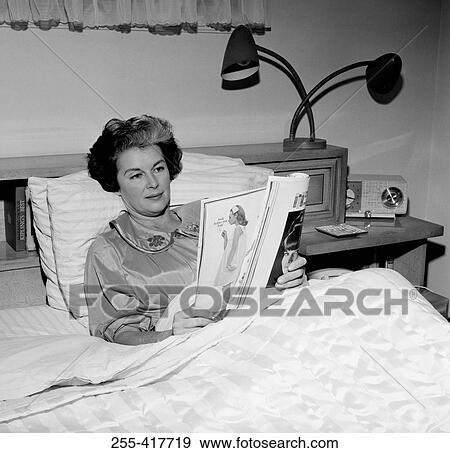 Mature woman sitting in bed, reading magazine View Large Photo Image Stock Photo - Mature woman sitting in bed, reading magazine. Fotosearch