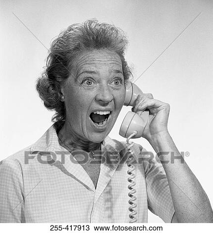 Stock Image - Mature woman yelling on telephone. Fotosearch