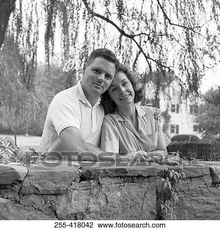 Stock Image - Mid adult couple embracing and smiling. Fotosearch