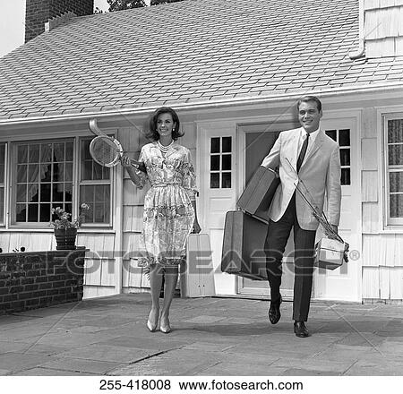 Stock Photo - Mid adult couple leaving house and going on vacations. Fotosearch