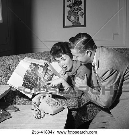 Mid adult couple looking at photograph in magazine View Large Photo Image Stock Photo - Mid adult couple looking at photograph in magazine. Fotosearch