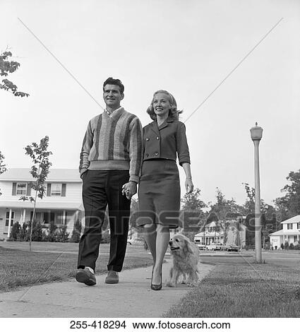 Picture - Mid-adult couple walking with dog. Fotosearch
