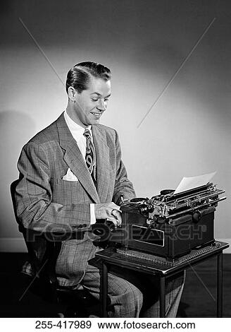 Stock Photo - Mid adult man typing on typing machine. Fotosearch