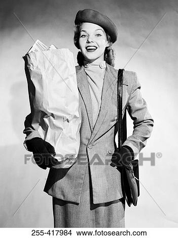 Mid adult woman holding shopping bag and smiling View Large Photo Image Picture - Mid adult woman holding shopping bag and smiling. Fotosearch